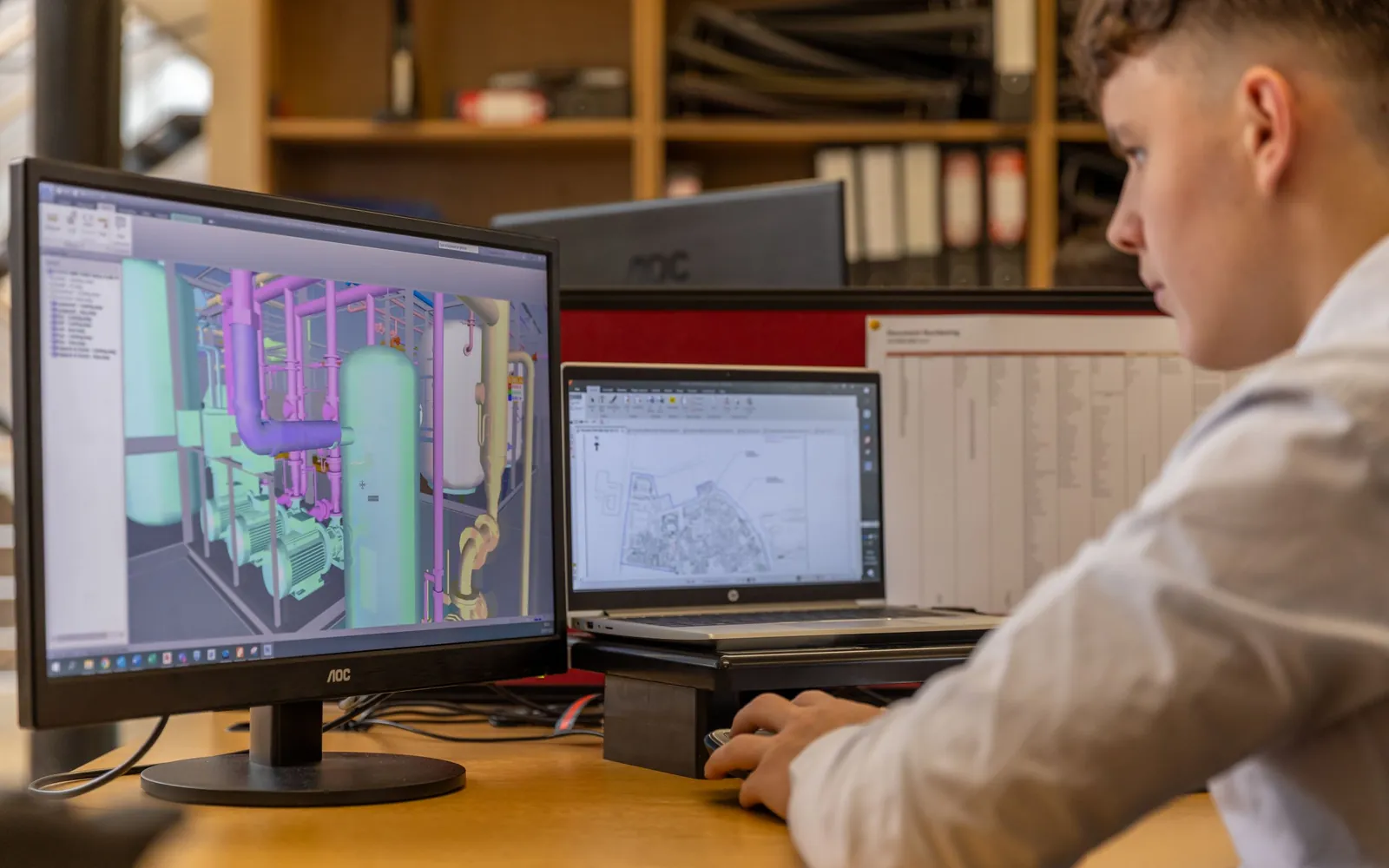 Konstrukteur arbeitet an einem 3D-CAD-Modell an zwei Bildschirmen